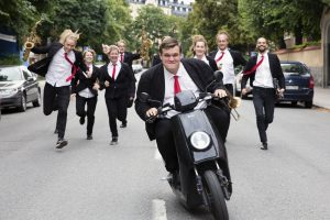 Fredrik conduce su scooter mientras su banda le persigue