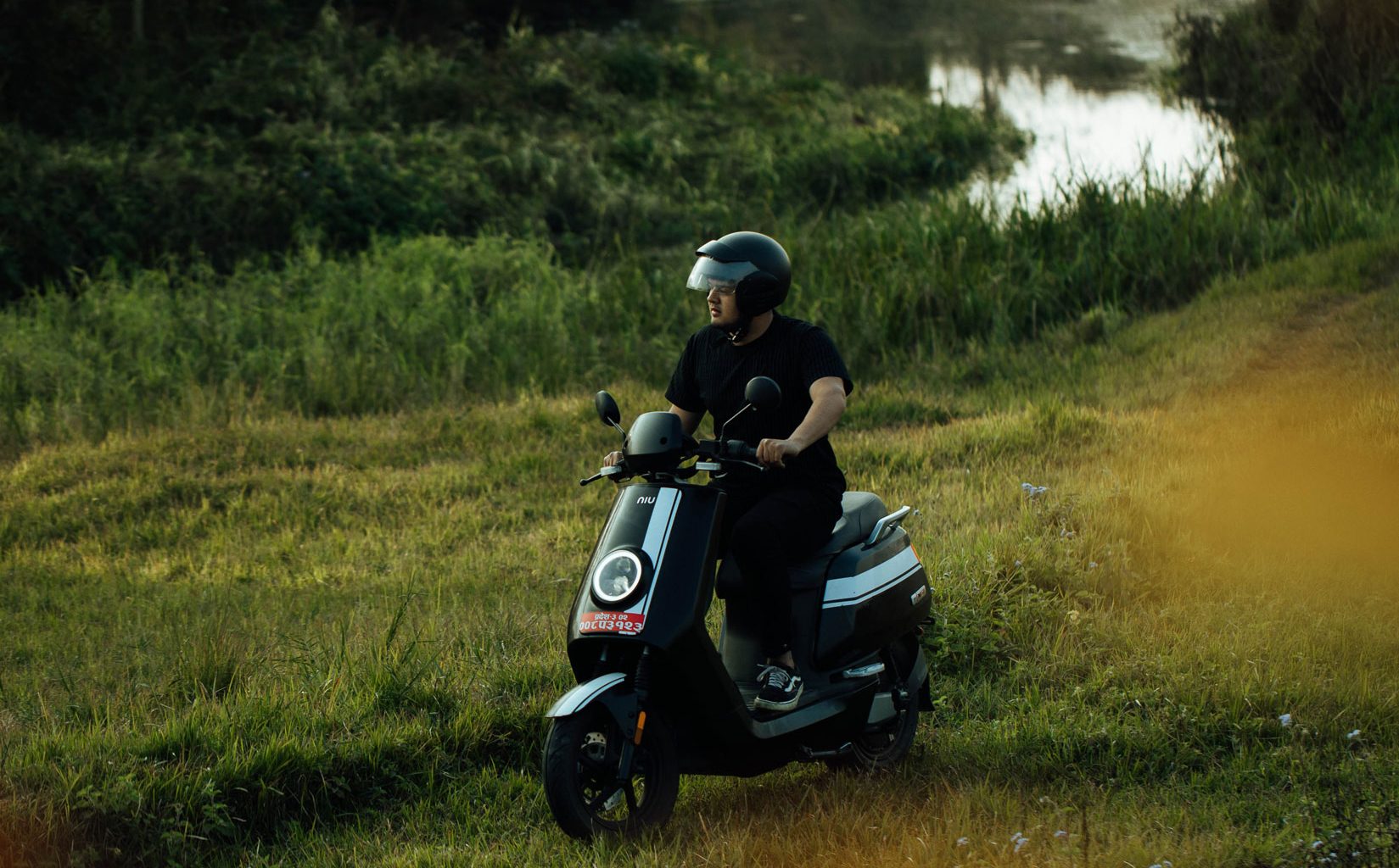 Een man rijdt een elektrische scooter in een natuurlijke omgeving
