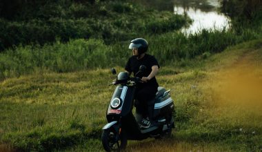 A man rides an electric scooter through a natural environment
