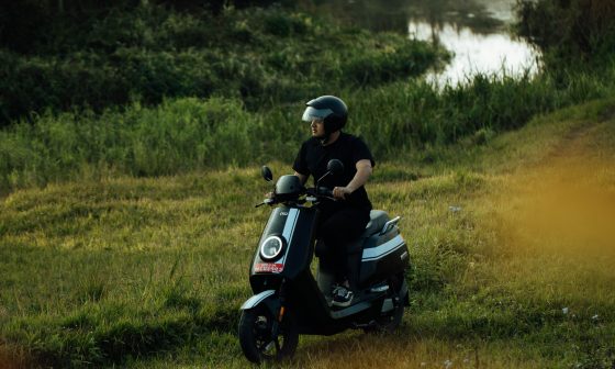 Un uomo guida uno scooter elettrico in un ambiente naturale