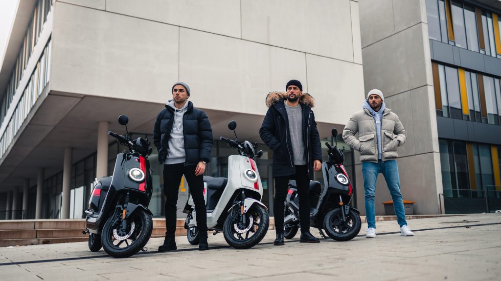 Three NIU scooters and their riders